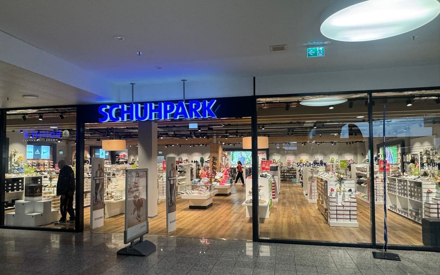 Verkaufsfläche der Filiale Schuhpark im Einkaufszentrum, Blick von der Mall auf den Eingang